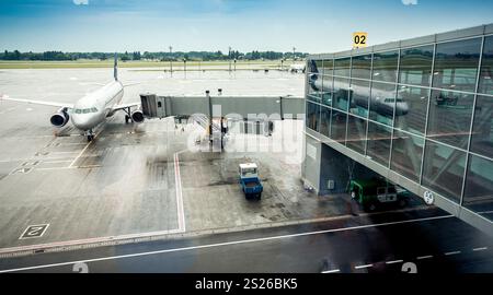 Grande aereo di linea parcheggiate accanto alla porta di imbarco in aeroporto Foto Stock