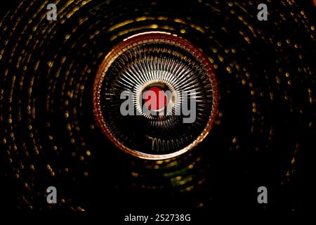 Un'affascinante spirale dorata astratta con linee irradianti e particelle luminose su uno sfondo scuro Foto Stock