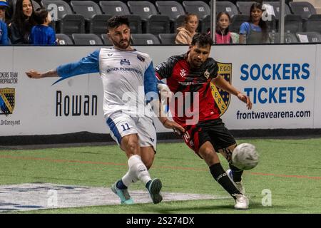 Oceanside, California, Stati Uniti. 5 gennaio 2025. Il Chihuahua Savage attaccante/centrocampista José Gilberto ''Huevo'' Lopez (14) tenta di prendere il controllo del pallone contro il centrocampista dei San Diego Sockers Leonardo de Oliveira (11). I Sockers vinsero la vittoria per sei a quattro contro il team Savage dopo un estenuante incontro alla Frontwave Arena di Oceanside, California, il 5 gennaio 2025. (Credit Image: © Jake Lee Green/ZUMA Press Wire) SOLO PER USO EDITORIALE! Non per USO commerciale! Crediti: ZUMA Press, Inc./Alamy Live News Foto Stock