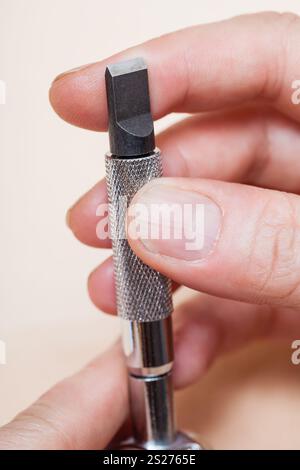 Lavorazione cuoio strumento girevole - coltello in mano da vicino Foto Stock