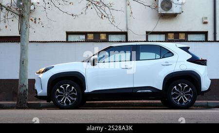 Bucarest, Romania – 4 gennaio 2025: Vista ravvicinata dell'auto bianca ibrida Toyota Yaris Cross parcheggiata sulla strada Foto Stock
