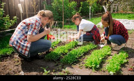 Immagine della famiglia sarchiatura e rompendo il terreno a giardino nel cortile Foto Stock