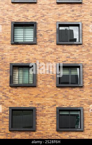 dettagli dell'edificio residenziale in mattoni, con finestre quadrate, struttura della facciata dell'area residenziale, architettura e design Foto Stock