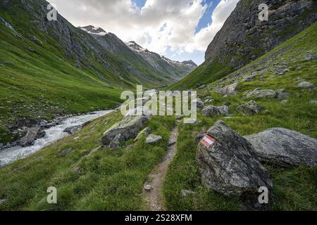 Sentiero escursionistico nella valle Umbaltal con il torrente Isel, le cime glaciali alle spalle, il gruppo Venediger, il Parco Nazionale degli alti Tauri, il Tirolo Orientale Foto Stock