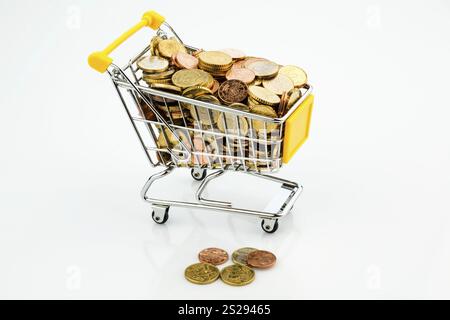 Un carrello della spesa è ben pieno di monete in euro, simboleggiando il potere d'acquisto e il consumo dell'Austria Foto Stock