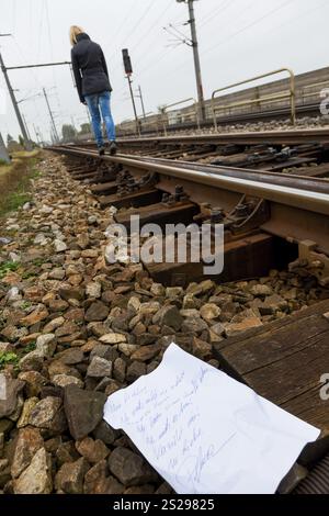 Una giovane donna lascia una lettera di addio e cammina su un binario ferroviario con l'intenzione di suicidarsi. Lettera in tedesco Foto Stock