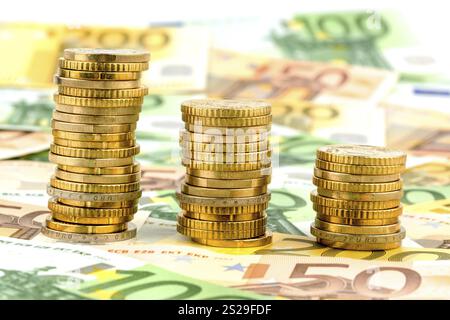 Pila di monete, curva discendente, foto simbolica per il calo dei tassi di interesse e i costi in calo Austria Foto Stock