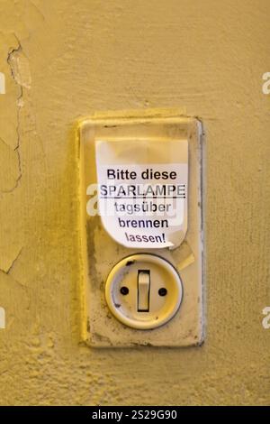 Vecchio interruttore luminoso con etichetta, lasciare accesa la lampadina a risparmio energetico durante il giorno in Austria Foto Stock