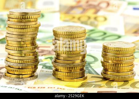Pila di monete, curva discendente, foto simbolica per il calo dei tassi di interesse e i costi in calo Austria Foto Stock