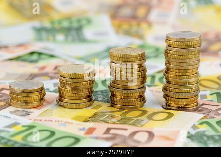 Pila di monete, curva in aumento, foto simboliche per l'aumento dei profitti e anche per l'aumento dei costi Foto Stock