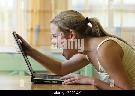 Una donna è infastidita dal suo computer. Problemi con hardware, software e shopping su Internet Austria Foto Stock