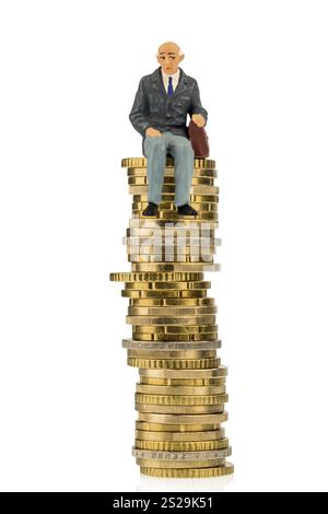 Un pensionato siede su un mucchio di monete. Foto simbolo per pensione e penison Foto Stock
