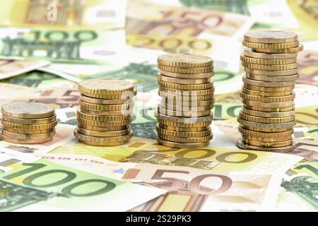 Pila di monete, curva in aumento, foto simboliche per l'aumento dei profitti e anche per l'aumento dei costi Foto Stock