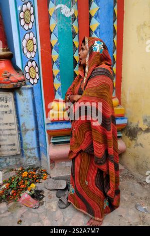 Una donna che si trova davanti al cancello del tempio Shri Bade Hanuman Ji ad Ayodhya, Uttar Pradesh, India. Foto Stock