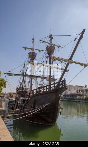 Siviglia, Spagna - 27 agosto 2024: NAO Victoria replica, prima nave in circumnavigazione, ancorata sulle rive del Guadalquivir. Arco Foto Stock