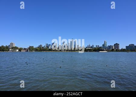 Vista dello skyline di Melbourne in lontananza, con il lago Albert Park pieno di uccelli in primo piano Foto Stock