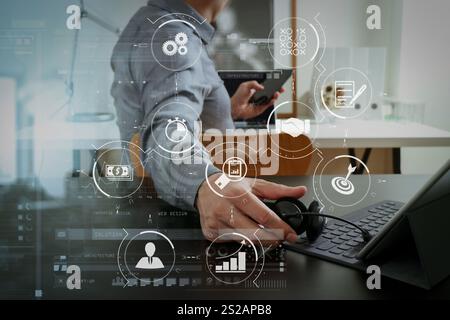 Gestione dei processi aziendali con diagramma di automazione del flusso di lavoro e ingranaggi nel diagramma di flusso virtuale.uomo d'affari che utilizza una cuffia VoIP con elaborazione tablet digitale Foto Stock