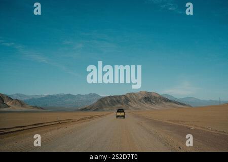 Vista posteriore di un veicolo fuoristrada che percorre una strada sterrata in un remoto paesaggio selvaggio, il Cile Foto Stock