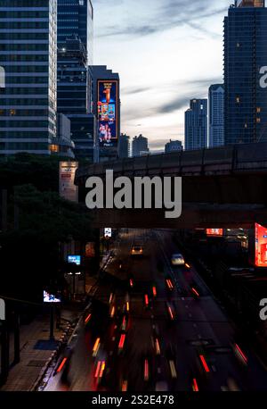 Questa accattivante immagine mostra i percorsi leggeri dei veicoli allo svincolo di Chong Nonsi a Bangkok, con la pista BTS ben sopra la testa. Lo scen Foto Stock