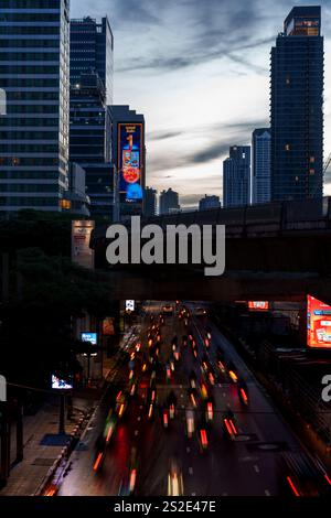 Questa accattivante immagine mostra i percorsi leggeri dei veicoli allo svincolo di Chong Nonsi a Bangkok, con la pista BTS ben sopra la testa. Lo scen Foto Stock