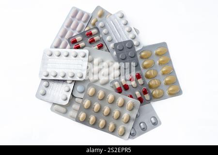 Natura morta. Primo piano delle confezioni blister dei medicinali visualizzate dall'alto e che formano un punto interrogativo su sfondo bianco Foto Stock