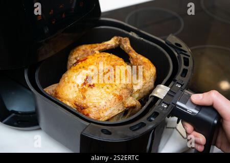 Cuocere il pollo intero nella friggitrice ad aria Foto Stock