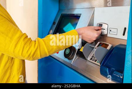 Una donna compra un biglietto del treno in una biglietteria. Foto Stock