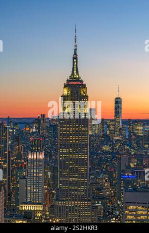 Vista dello skyline di Manhattan con l'Empire State Building illuminato al tramonto Manhattan, New York, New York, Stati Uniti Foto Stock