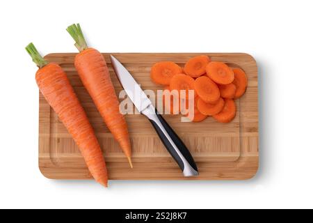 Tagliere con sfondo bianco. Un coltello, carote fresche intere e tagliate. Cucinare. Foto Stock