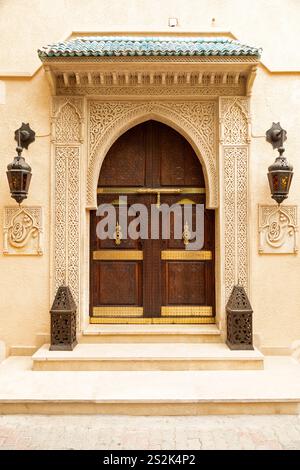 Porta ad arco un riad nella Medina di Marrakech, in Marocco. L'intricato motivo intorno alla porta è un esempio di intonaco tadelakt. Foto Stock