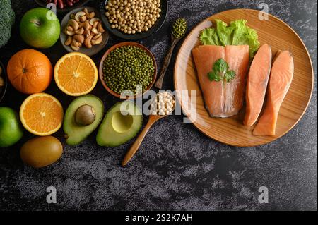 Legumi, frutta e salmone su un piatto di legno. Foto Stock