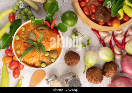 Pollo al curry rosso in una ciotola nera, peperoncino, pomodoro, galangal, funghi shiitake e melanzane Foto Stock