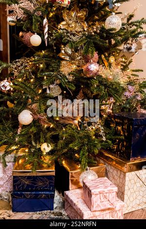 Regali avvolti sotto l'albero di Natale decorato Foto Stock