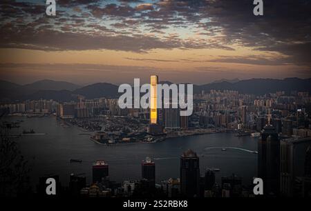 Questa immagine mostra una vista aerea mozzafiato di una città vivace al tramonto, con un grande e tranquillo specchio d'acqua che riflette magnificamente il cielo nel fo Foto Stock