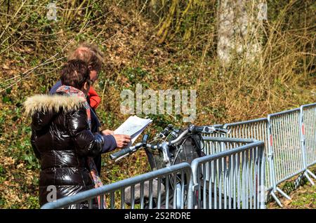 Wallers-Arenberg, Francia - 12 aprile 2015: Due spettatori che analizzano il percorso con una mappa in mano sul famoso settore asfaltato, l'Arenber Foto Stock