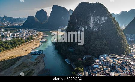 Vista aerea di Yangshuo e del fiume li mentre si snoda attraverso un paesaggio mozzafiato, circondato da maestose montagne carsiche Foto Stock