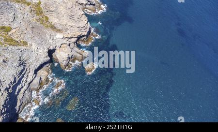 Vista aerea mozzafiato delle scogliere rocciose che incontrano le vibranti acque turchesi del mar mediterraneo in la manga del mar menor, una splendida estate Foto Stock