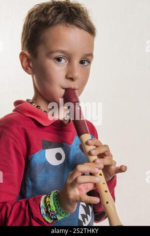 Un bambino suona un flauto sul legno. Educazione musicale e scuola di musica. Austria Foto Stock