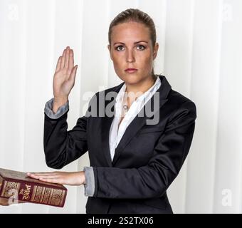 Una donna testimonia come testimone in un caso giudiziario. Ha giurato e giura sulla Bibbia. Austria Foto Stock