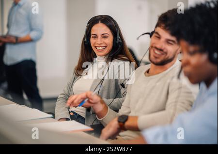 Donna sorridente del servizio clienti con auricolare che lavora in ufficio. Giovane operatore donna che lavora in un call center e parla con i clienti Foto Stock