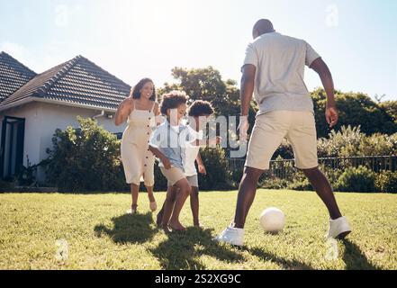 Felice, calcio e genitori che giocano con i bambini nel cortile per giocare, avventura o tempo libero in famiglia. Divertimento all'aperto e apprendimento del calcio per bambini con la mamma Foto Stock