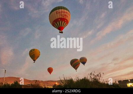 Le colorate mongolfiere sorvolano il deserto del sahara offrendo ai visitatori vedute della vasta necropoli di tebe vicino a Luxor, in Egitto Foto Stock