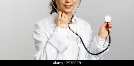 Donna in camicia bianca con colletto in mano uno stetoscopio Foto Stock