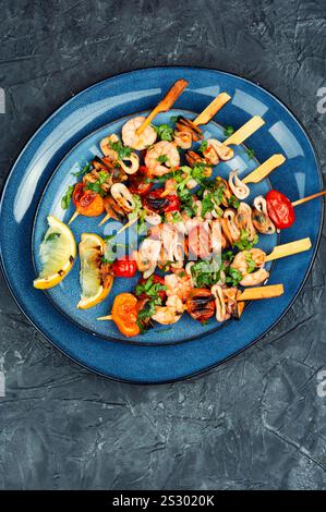 Kebab di pesce al barbecue, gamberetti, cozze e calamari grigliati sugli spiedini. Vista dall'alto. Foto Stock