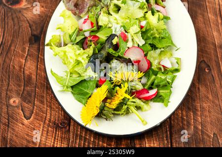 Insalata di verdure, ravanelli e leoni su tavola rustica in legno. Pianta commestibile. Foto Stock