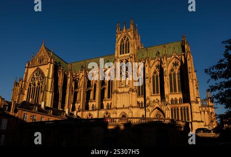 Cattedrale gotica alla calda luce del sole serale con un'architettura intricata e guglie torreggianti sotto un cielo blu chiaro e profondo. Francia, Metz Foto Stock