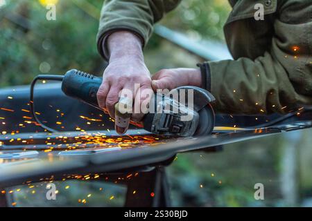 uomo con un dito rotto che taglia il metallo Foto Stock