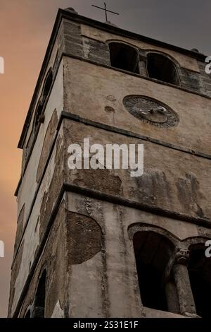 Scaglie provenienti dalle pareti esterne di un campanile romanico che sorge accanto alla chiesa di San Giorgio il giovane, risalente alla fine del XV secolo, nella città fortificata di Plomin, provincia dell'Istria, Croazia, oggi per lo più disabitata. Foto Stock