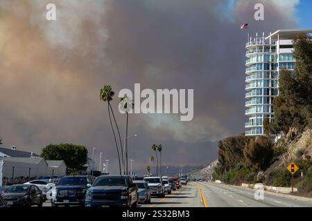 Los Angeles, Stati Uniti. 7 gennaio 2024. Il fumo copre il percorso di evacuazione sulla Pacific Coast Highway a Pacific Palisades, Los Angeles, California. Più di 30.000 furono ordinati di evacuare le aree della California meridionale mentre i venti di Santa Anna attraversavano la regione. L'elevata popolazione, le condizioni di siccità, l'abbondanza di combustibile e la forza del vento di montagna hanno creato un ambiente ad alto rischio di incendio che ha il potenziale di propagarsi. (Foto di Michael Nigro/Pacific Press) credito: Pacific Press Media Production Corp./Alamy Live News Foto Stock
