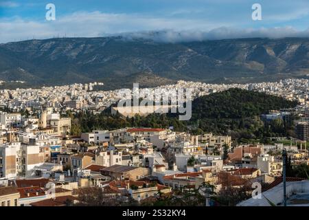 Un'ampia vista aerea cattura una città vivace con imponenti montagne che incombono maestosamente sullo sfondo, mettendo in mostra sia la natura che la città Foto Stock